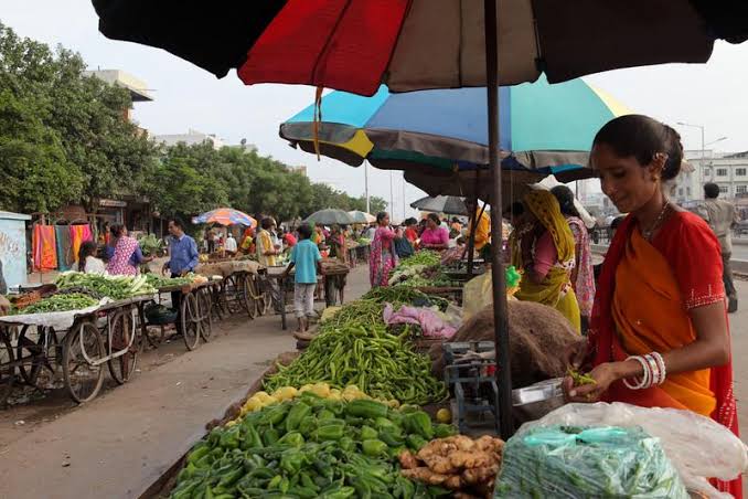 Woman selling green chillies from a cart